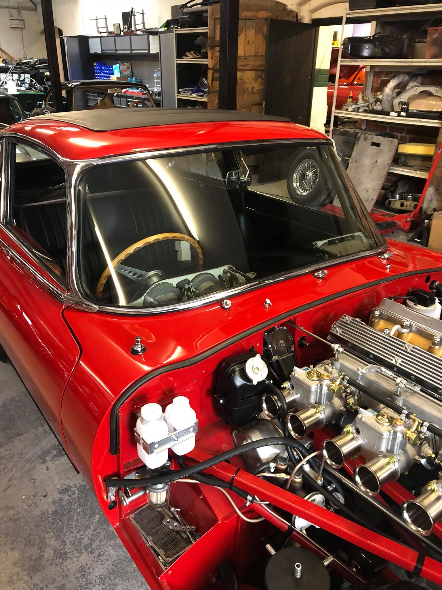 Classic red car with a newly fitted windscreen in the Burton Windscreens workshop