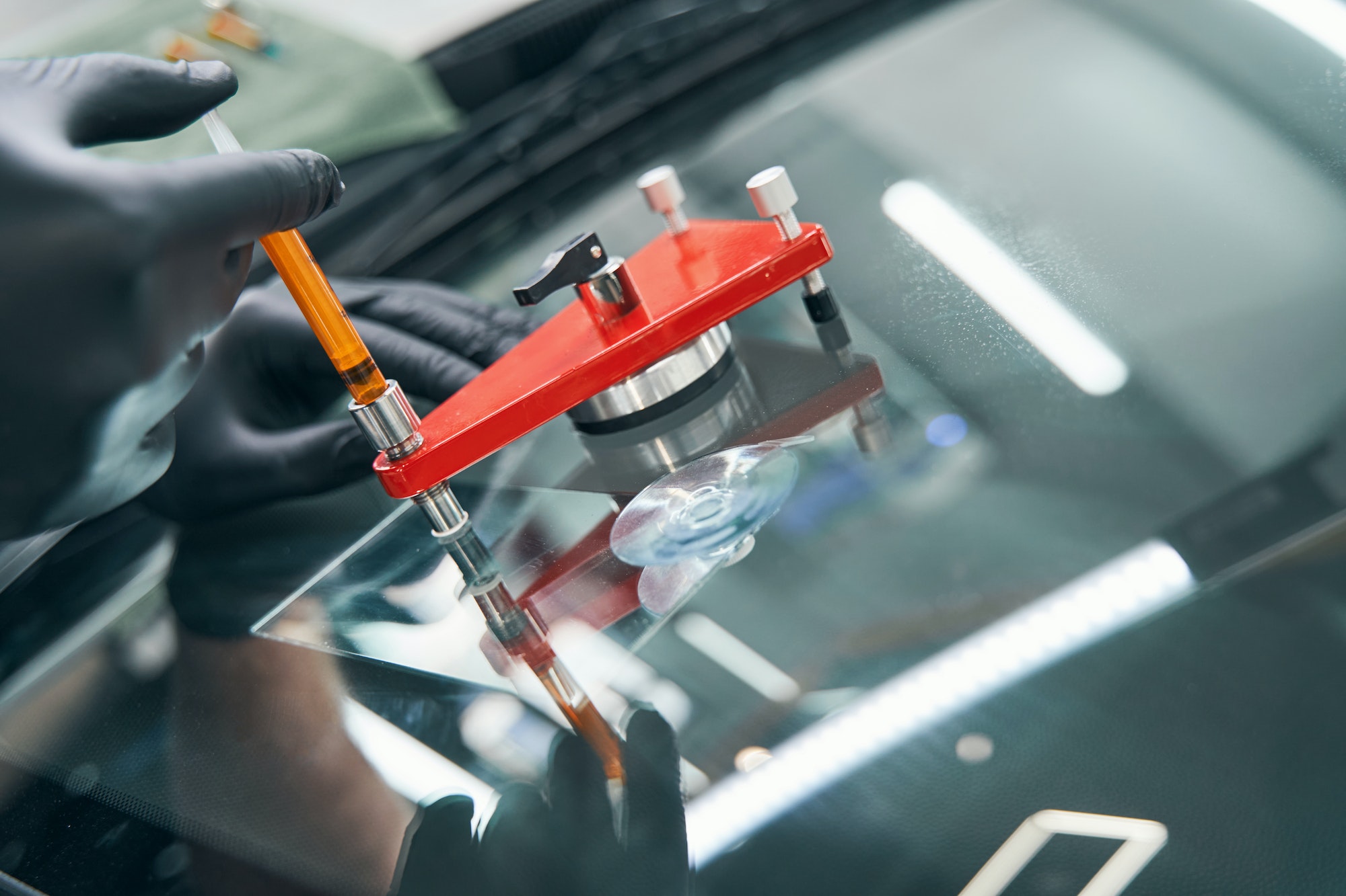 Serviceman repairing a damaged car windscreen